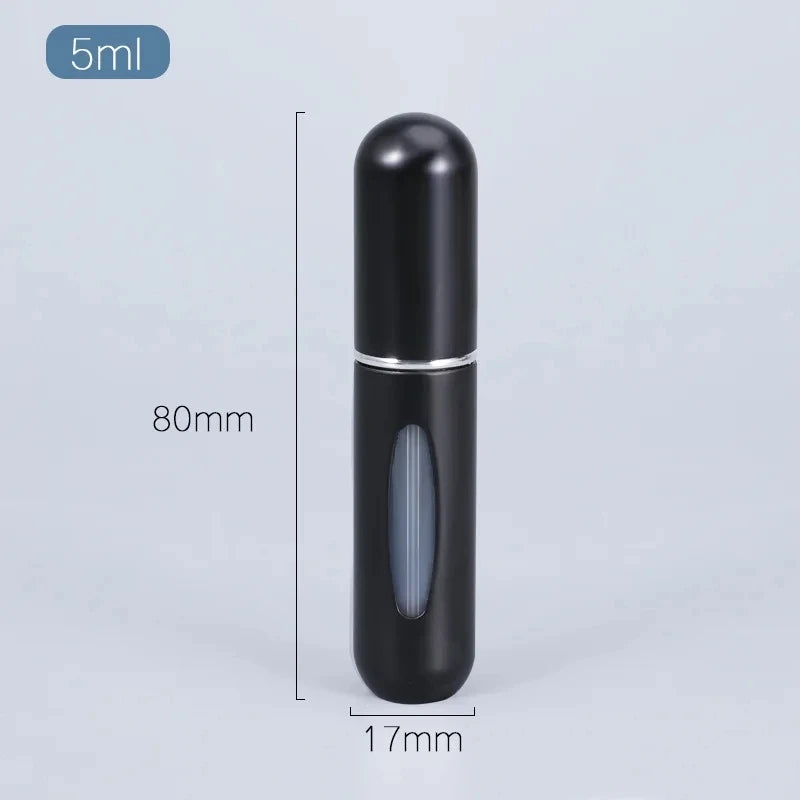 Flacon de parfum cylindrique noir rechargeable avec pompe argentée sur fond gris clair.