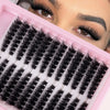 A close-up of a pink beauty box containing numerous black cluster eyelashes for DIY beauty.