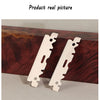 Two stainless steel single-sided razor blades resting on a dark wooden surface.