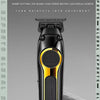 A black Kemel electric hair clipper is shown vertically against a gray background.