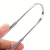 A hand holds a stainless steel tongue scraper, showing the tool's shape and size.