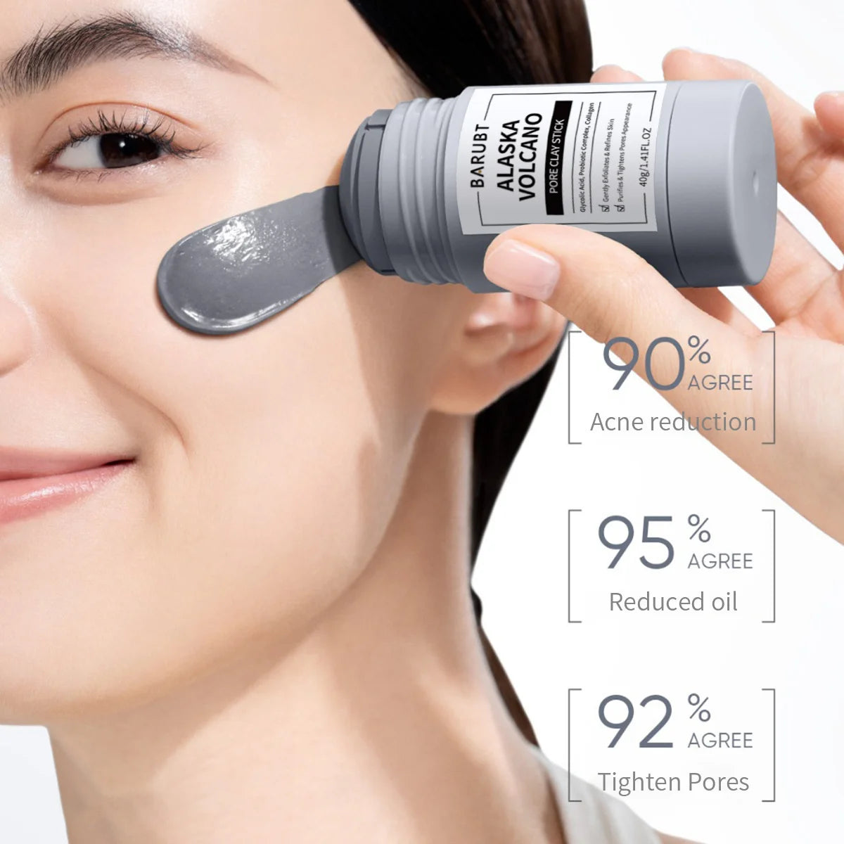 A hand applies a grey stick-shaped mask to a woman's face for pore cleansing.