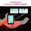 A hand holds a device emitting red light onto a white therapeutic belt for light therapy testing.
