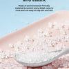 A white silicone tongue scraper is shown on a pink tray with small, translucent silicone pieces.