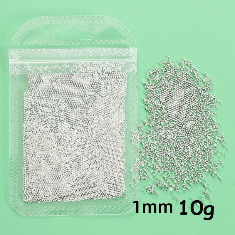 A clear plastic bag containing 10 grams of gold mixed stainless steel bead nail art decorations.