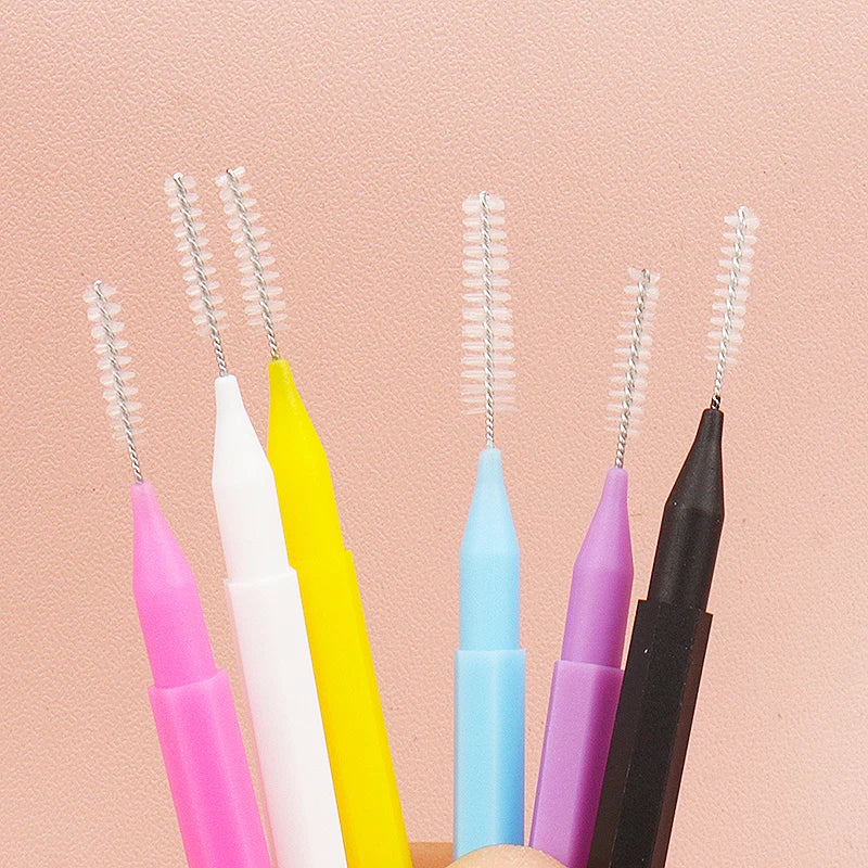 A collection of various colored precision eyebrow and lash brush sets displayed against a light pink background.