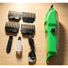 A professional cordless hair clipper trimmer shown with various attachments and a battery on a wooden surface.