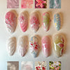 Colección de 12 uñas postizas brillantes con diversos tonos de rosa, verde e iridiscentes.