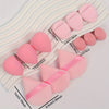 A set of twelve pink makeup sponges arranged on a white surface with size measurements.
