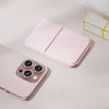 Pinkes faltbares Make-up-Spiegel mit Smartphone und goldgerahmte Box auf hellem Untergrund.