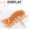 A golden-colored silicone facial massage tool used for real time display.