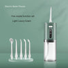 A light luxury green electric water flosser with five nozzle tips displayed next to the device.
