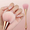 A rose gold makeup brush set featuring a fluffy pink brush and a tapered applicator, held by a hand.