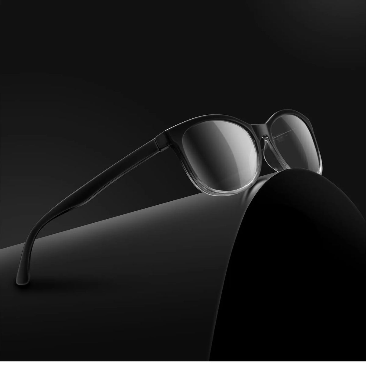 Une paire de lunettes de lecture noires multifocales avec protection anti-lumière bleue sur une surface sombre.