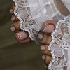 Close-up of hands with short square French press-on nails and sheer white lace fabric