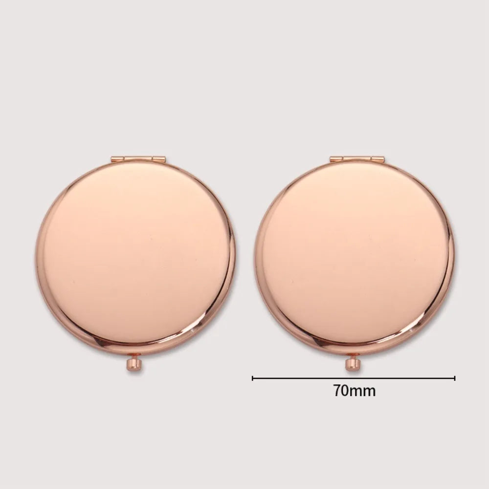 A round, rose gold portable folding makeup mirror with a magnifier.