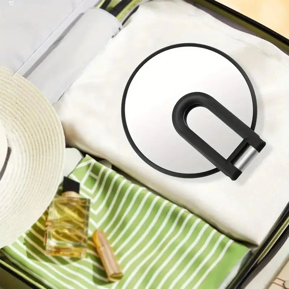 Miroir de voyage à double face dans une pochette rayée verte avec doublure en tissu blanc.
