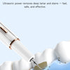 A white ultrasonic tooth cleaner device is shown cleaning a tooth surface with a small, targeted tip.