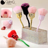 Un set de pinceles de maquillaje rosados y morados mostrados en una caja brillante.