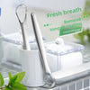 Stainless steel tongue scraper shown next to a white container and a green leaf.