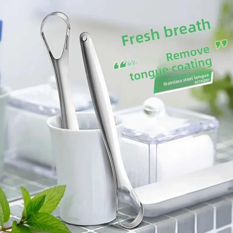 Stainless steel tongue scraper shown next to a white container and a green leaf.