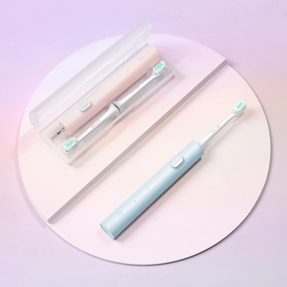 A pink sonic electric toothbrush with a white handle and blue bristles is displayed on a white background.