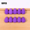 Ten purple makeup sponge puffs arranged in two rows on a wooden surface.