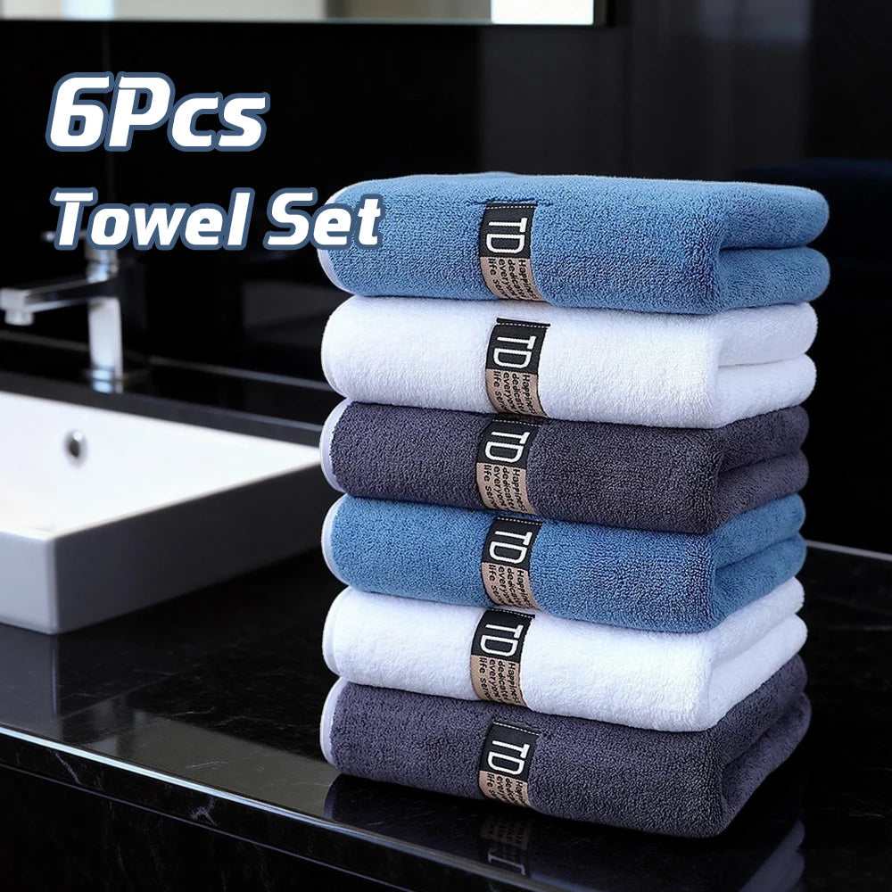 A stack of six blue, white, and gray microfiber cleaning towels is displayed on a black countertop.