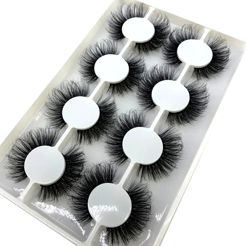 Un assortiment de huit paires de faux cils de renard noir sont présentées dans un plateau en plastique transparent.