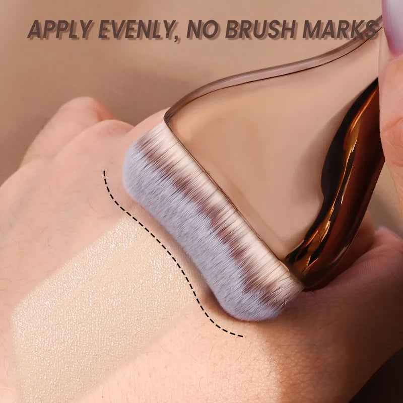 A hand applies foundation evenly using a professional foundation brush with soft nylon bristles on the skin.