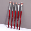 A set of five red makeup brushes with pink bristles displayed against a gray background.