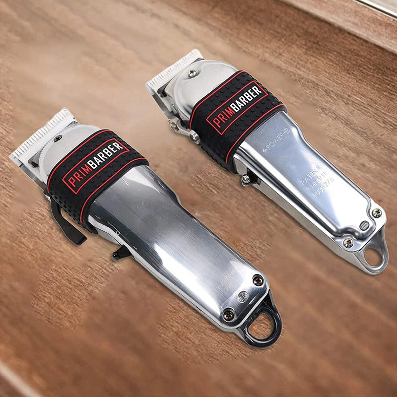 A pair of silver electric trimmer grips with black silicone anti-slip handles and red branding lying on a wooden surface.