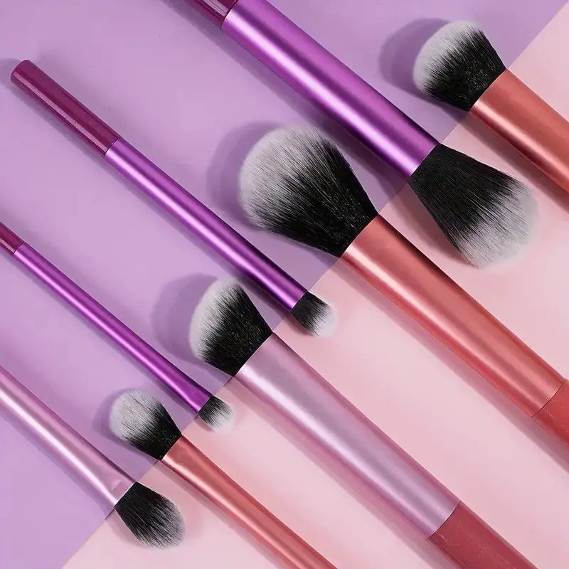 Eight professional makeup brushes in various shades of pink and purple with black and silver bristles