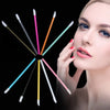 A woman applies makeup using various colored disposable lip brushes and nylon applicator wands.