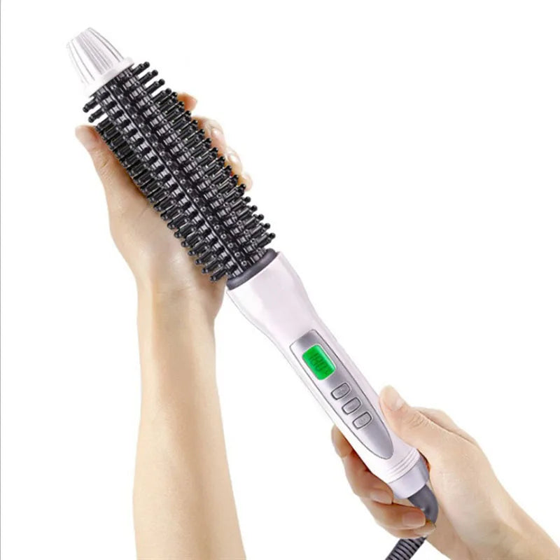 A hand holds a black ceramic hair straightener and curler with a white and pink handle.