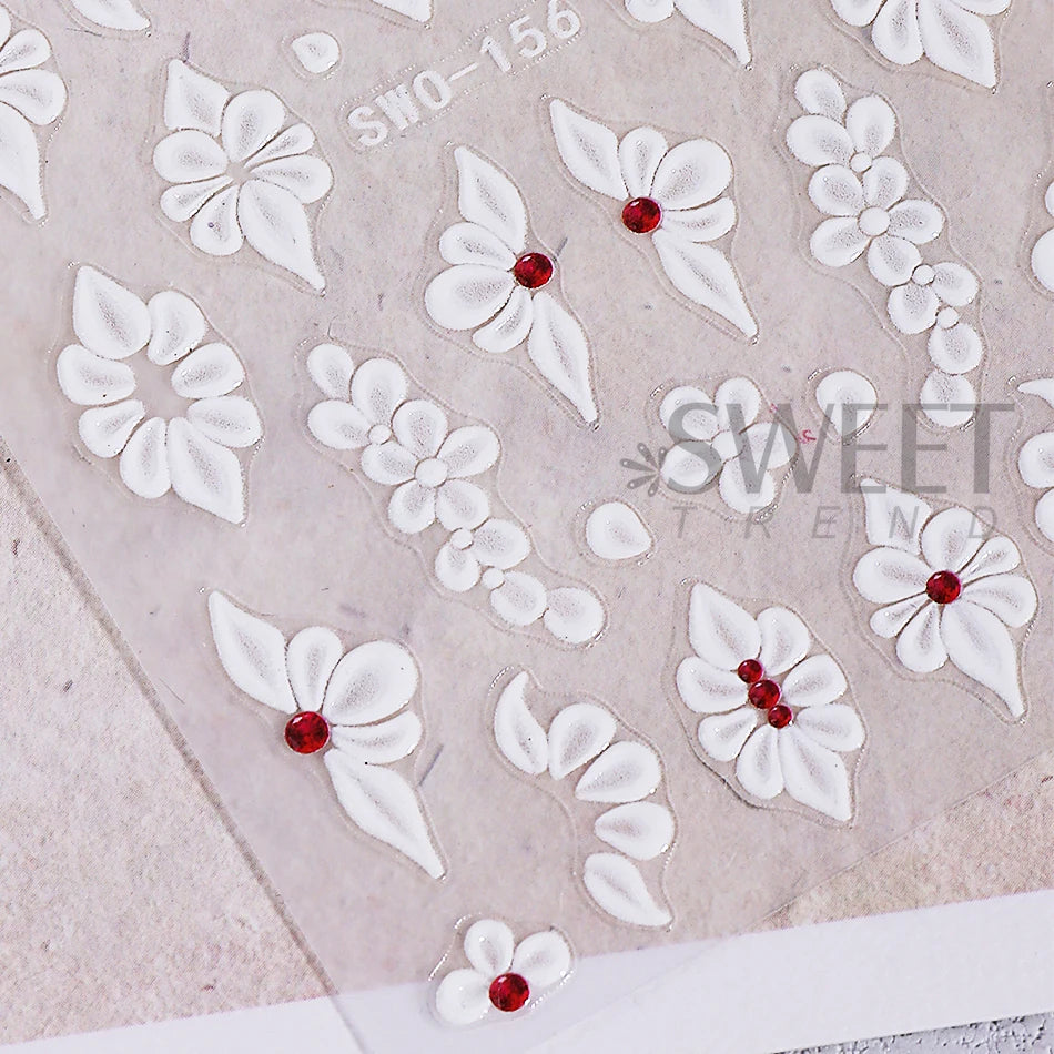 White embossed floral nail stickers featuring small red accents on a translucent background.