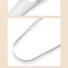 A close-up view of a reusable stainless steel tongue scraper and oral brush tool.