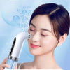 A woman is using a white micro bubble pore vacuum cleanser device on her face with bubbles visible in the air.