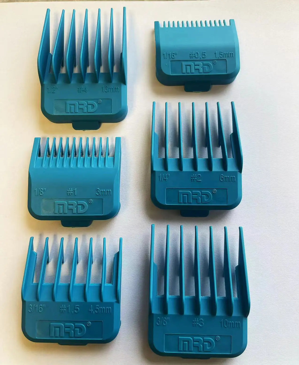 A collection of various blue professional electric hair trimmer guards and attachments.