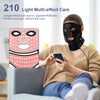 A woman is using a black LED facial mask on her face while looking at her smartphone.