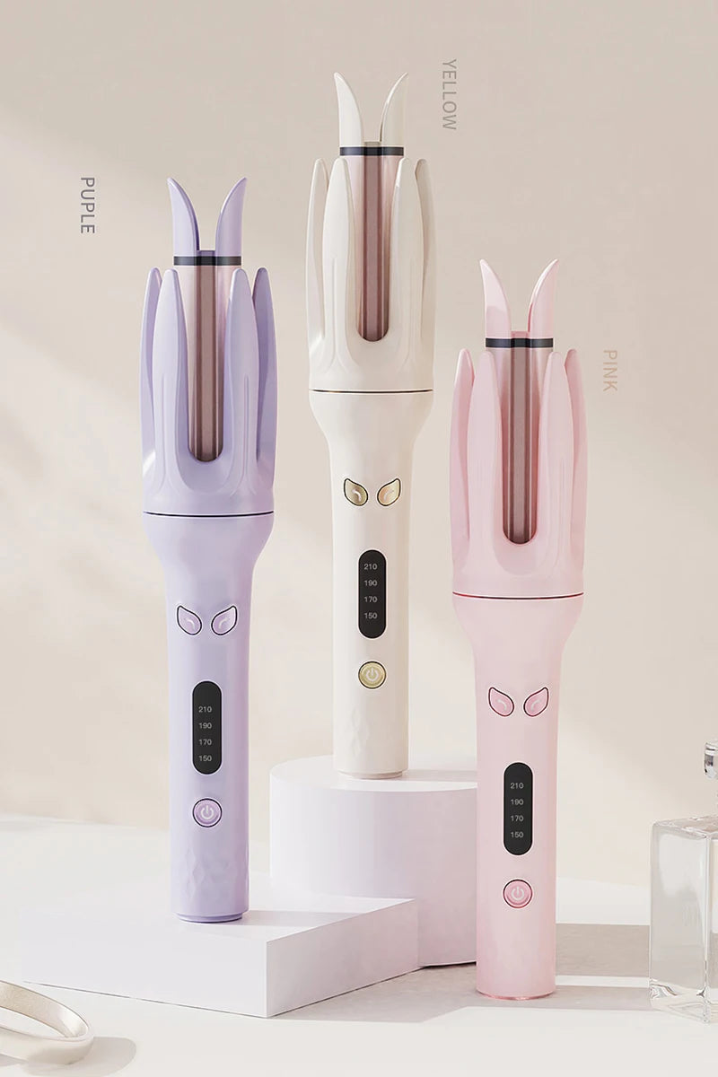 Three automatic ceramic hair curlers in purple, yellow, and pink are displayed vertically on a white surface.