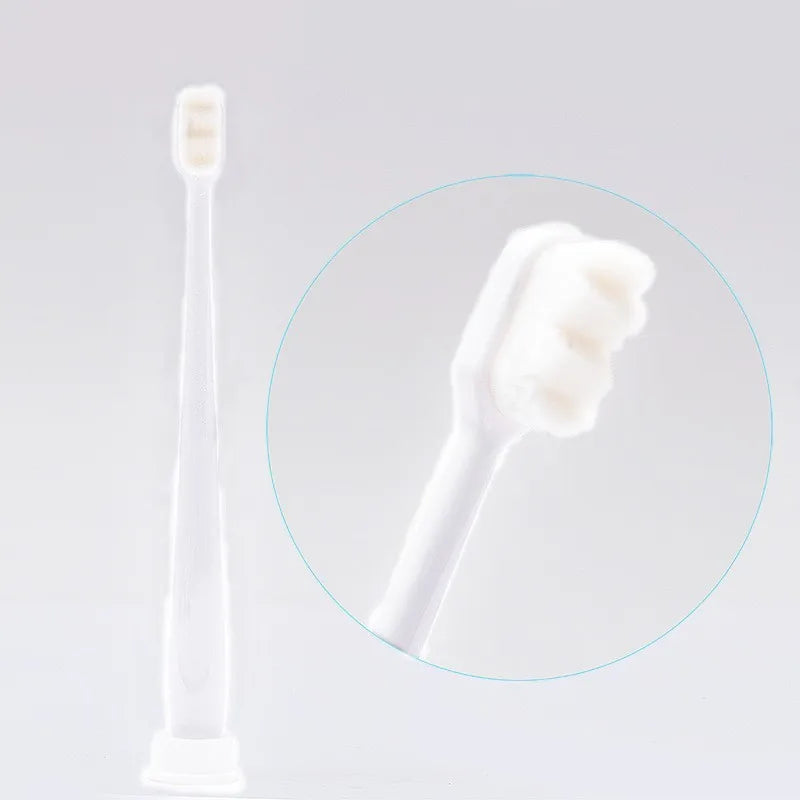 A white ultra-soft microbristle toothbrush is shown in a magnified circle against a light background.