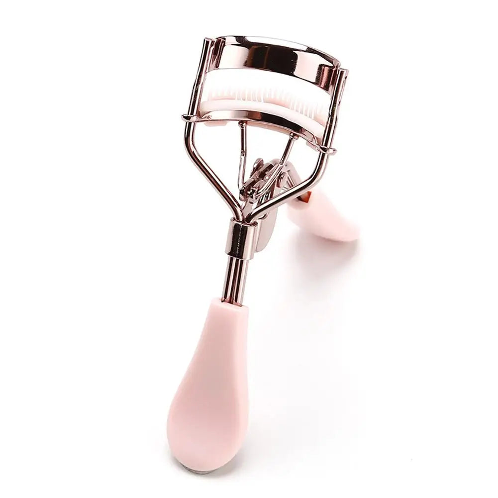 Un recourbe-cils rose professionnel avec un peigne, présenté sur fond blanc.