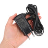 A black power adapter and cable for a professional barber shaver is held in a hand.