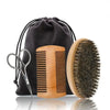 A set of boar bristle beard brush and comb in a wooden holder with a black fabric gift bag.