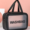 A black cosmetic storage bag with a clear window displaying the word WASHBAG against a pink background.