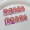 Un set de uñas postizas de perla rosa nude con varios tonos y acentos florales.