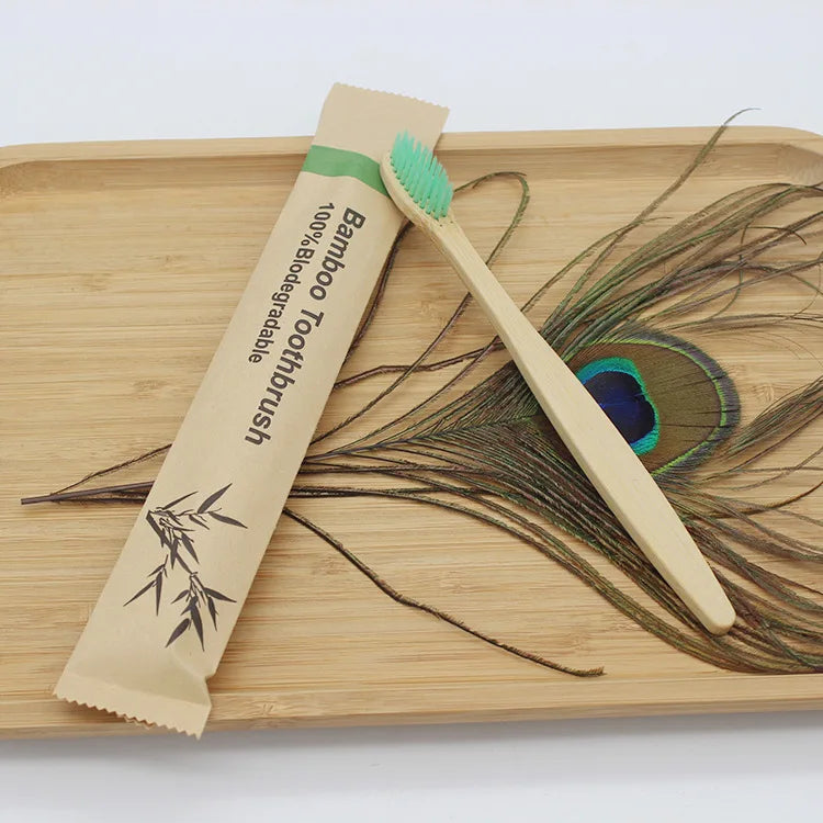 A bamboo toothbrush packaged in paper is shown next to a single bamboo toothbrush on a wooden cutting board.