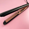 A professional ceramic flat iron hair straightener shown in black and rose gold tones against a pink background.