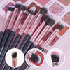 A collection of professional makeup brushes in various shades and sizes displayed on a pink background.